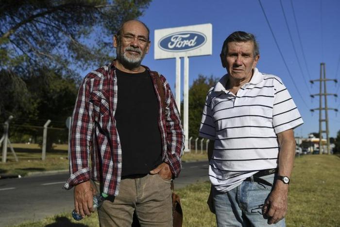 Carlos Propato (L) and Pedro Troiani, former workers of Ford and former political prisoner, pose during an interview with AFP outside Ford’s General Pacheco plant in Buenos Aires on March 16, 2018