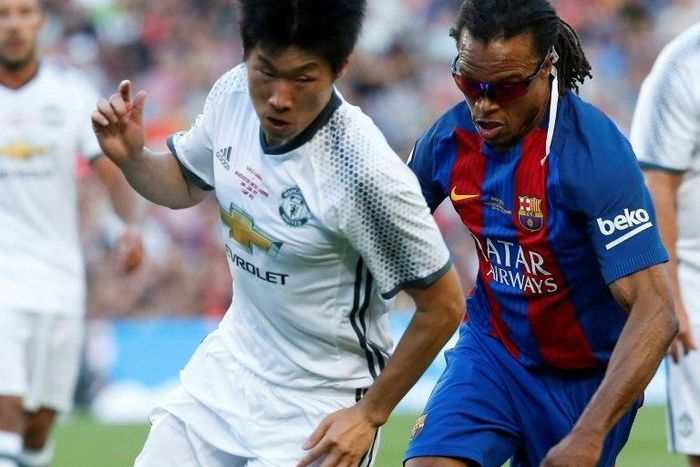 Former Barcelona star Edgar Davids (R) fights for the ball with ex-Manchester United's South Korean midfielder Park Ji-Sung during a charity match in Barcelona, on June 30, 2017
