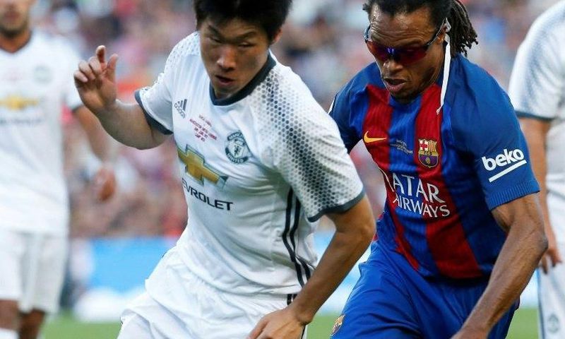 Former Barcelona star Edgar Davids (R) fights for the ball with ex-Manchester United's South Korean midfielder Park Ji-Sung during a charity match in Barcelona, on June 30, 2017