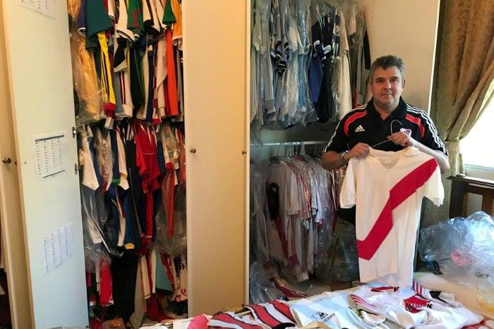 River Plate fanatic Javier Maluf poses with the Argentine's club jersey's at his home in Doha before setting out on his long trek to Madrid