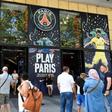 People stand in front the Paris-Saint-Germain football club store on the Champs Elysees avenue in Paris
