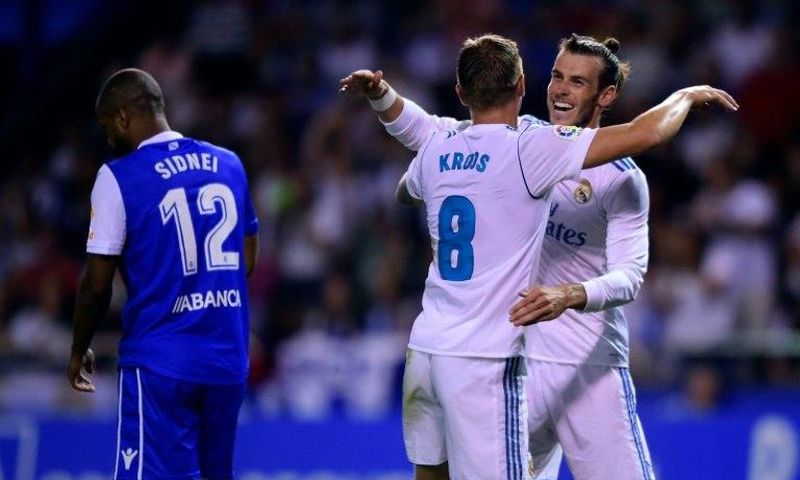Real Madrid's midfielder Toni Kroos (C) celebrates with teammate Gareth Bale scoring on August 20, 2017