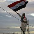 An Iraqi man waves his national flag in Baghdad's Tahrir Square on December 10, 2017, during a gathering celebrating the end of the three-year war against the Islamic State (IS) group