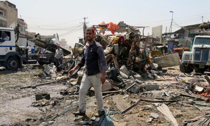 Iraqis look at the damage following a car bomb explosion in Baghdad's Shiite-majority district of Sadr City on August 28, 2017
