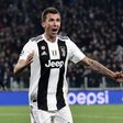 Juventus' forward Mario Mandzukic (L) celebrates as Valencia's midfielder Daniel Wass reacts, after opening the scoring during the UEFA Champions League group H football match Juventus vs Valence November 27, 2018