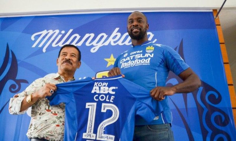 Cole (R) and Umuh Muchtar hold Cole's jersey during a press conference in March