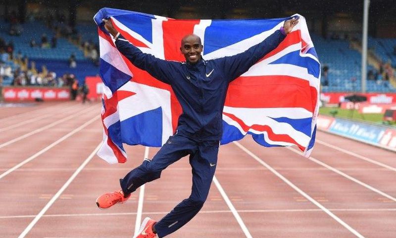 Britain's Mo Farah poses with a national flag after winning the men's 3,000m during the 2017 IAAF Birmingham Diamond League athletics on August 20, 2017