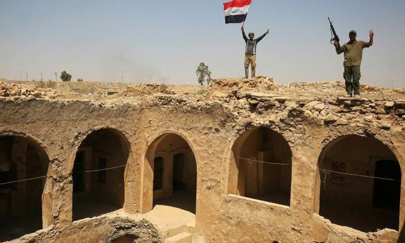 Fighters from the Hashed al-Shaabi paramilitary group raise the Iraqi flag over Tal Afar's historic Ottoman-era citadel after they and Iraqi forces seized it from Islamic State group jihadists
