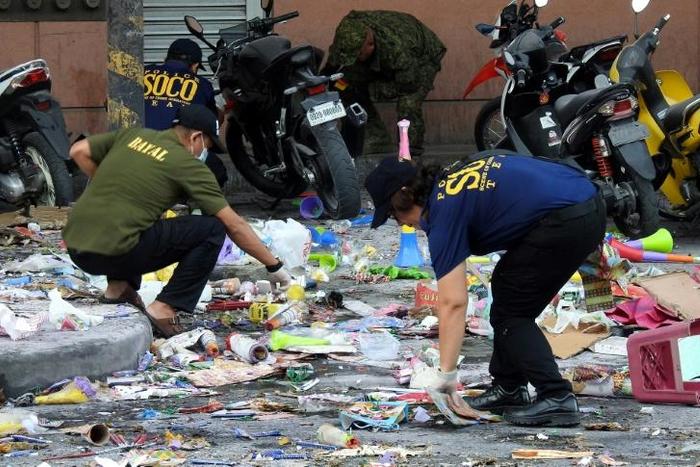 Scattered debris including items traditionally sold for New Year celebrations, such as cardboard and plastic horns and gifts, as well as a bloody slipper, lay at the mall's entrance where the explosion took place