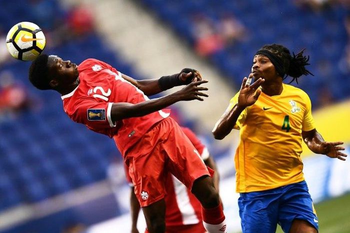 Canada's Alphonso Davies heads the ball next to French Guiana's Rhudy Evens during their 2017 CONCACAF Gold Cup Group A match, at the Red Bull Arena in Harrison, New Jersey, on July 7