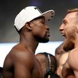 Boxer Floyd Mayweather Jr. (L) and UFC lightweight champion Conor McGregor face off during their official weigh-in at T-Mobile Arena on August 25, 2017 in Las Vegas, Nevada