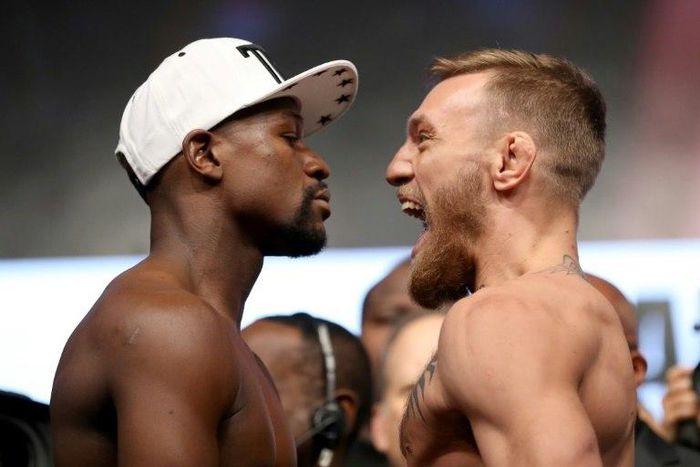 Boxer Floyd Mayweather Jr. (L) and UFC lightweight champion Conor McGregor face off during their official weigh-in at T-Mobile Arena on August 25, 2017 in Las Vegas, Nevada