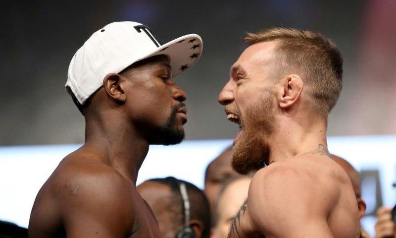 Boxer Floyd Mayweather Jr. (L) and UFC lightweight champion Conor McGregor face off during their official weigh-in at T-Mobile Arena on August 25, 2017 in Las Vegas, Nevada