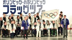 Tokyo governor Yuriko Koike waves the Olympic flag during a ceremony marking three years before the start of the Olympics