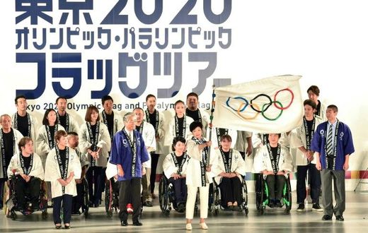 Tokyo governor Yuriko Koike waves the Olympic flag during a ceremony marking three years before the start of the Olympics