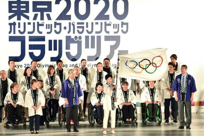 Tokyo governor Yuriko Koike waves the Olympic flag during a ceremony marking three years before the start of the Olympics