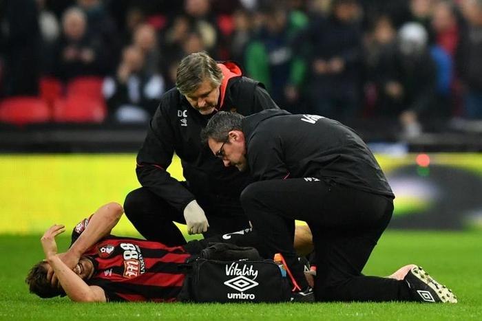 Bournemouth's English defender Simon Francis gets attention on the field for an injury during the English Premier League football match between Tottenham Hotspur and Bournemouth on December 26, 2018