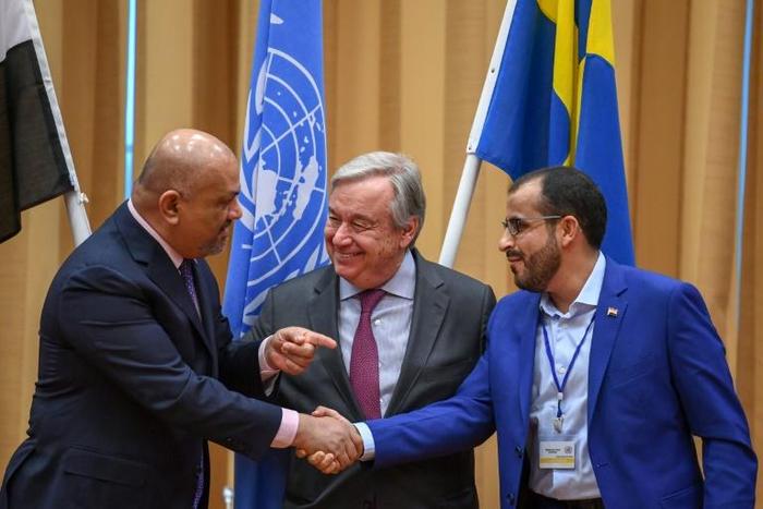 Yemen's foreign minister Khaled al-Yamani (L) and rebel negotiator Mohammed Abdelsalam (R) shake hands under the eyes of UN Secretary General Antonio Guterres (C), at Johannesberg Castle in Rimbo, Sweden, on December 13, 2018
