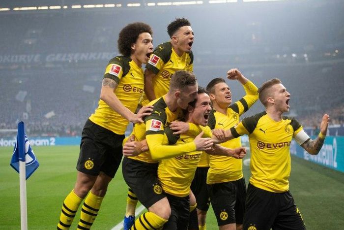 Thomas Delaney (bottom centre) is mobbed by his Dortmund team-mates after scoring against Schalke