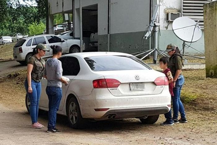 An Argentine woman (2-L) who was abducted 32 years ago and her nine-year-old son (2-R) being escorted by police officers into a car in Oran, Salta Province, Argentina