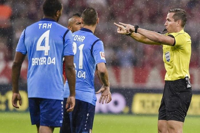 German referee Tobias Stieler gestures for the video assistant referee to review a decision during the Bundesliga match between Bayern Munich and Bayern Leverkusen on August 18, 2017
