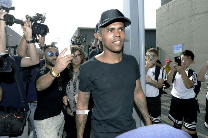 Brazilian football player Douglas Costa (C) is surrounded by supporters and photographers upon his arrival at the Juventus' Medical Center in Turin on July 12, 2017