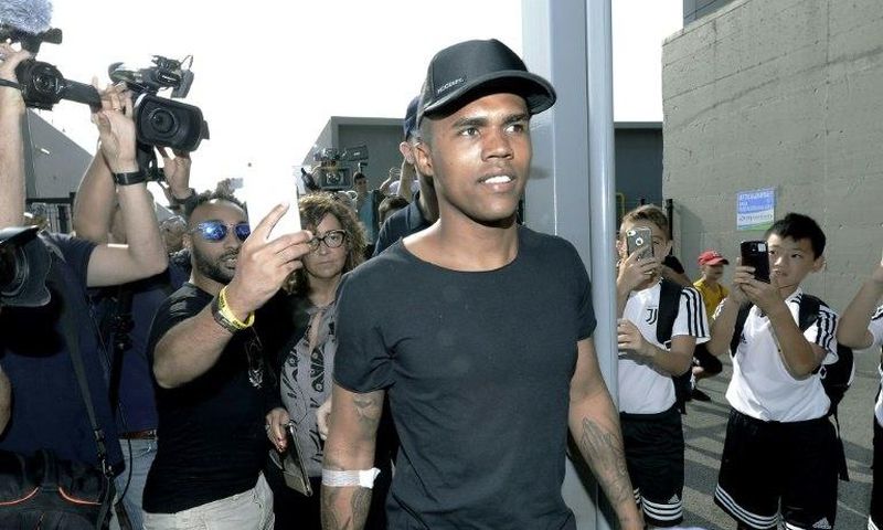Brazilian football player Douglas Costa (C) is surrounded by supporters and photographers upon his arrival at the Juventus' Medical Center in Turin on July 12, 2017