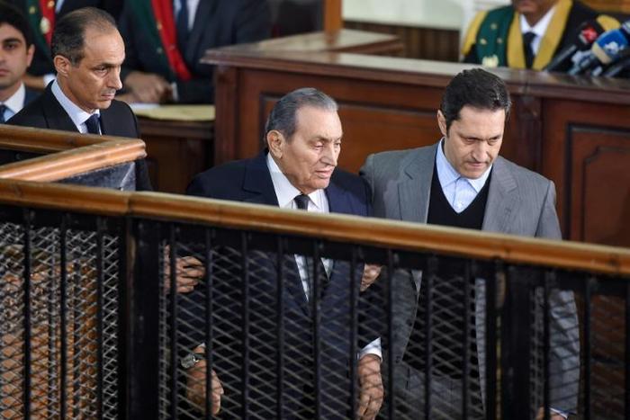 Former Egyptian president Hosni Mubarak is escoted by his two sons as he testifies against ousted Islamist president Mohamed Morsi in a Cairo court on December 26, 2018