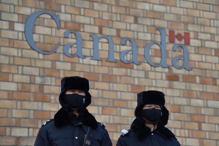 Chinese police officers stand guard outside the Canadian embassy in Beijing on December 10, 2018