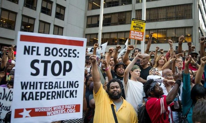 Activists raise their fists at a rally in support of NFL quarterback Colin Kaepernick outside the offices of the National Football League on Park Avenue, in New York City