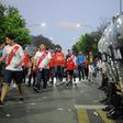 A tightly packed cordon of police holding riot shields surveys River Plate fans as they leave the Monumental stadium following the postponement of the Copa Libertadores final