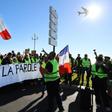 Protestors hold a banner reading "The people speak out" during a protest of 'yellow vests' against rising fuel prices and living costs, in the southern French city of Nice on December 8, 2018