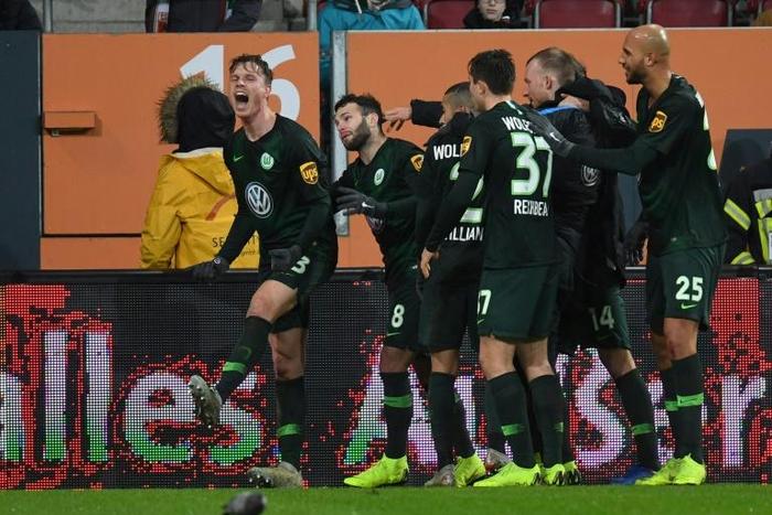 Midfielder Yannick Gerhardt (L) celebrates with his Wolfsburg teammates after his late goal sealed a thrilling 3-2 win at Augsburg to leave them fifth in the Bundesliga and four points from the Champions League places.