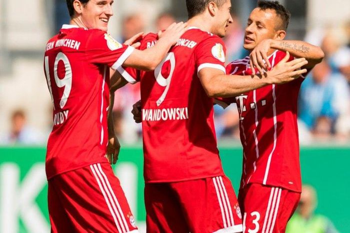 Munich's forward Robert Lewandowski (C) celebrates after scoring the first goal with midfielder Sebastian Rudy (L) and defender Rafinha during the German football Cup DFB Pokal first round match against Chemnitzer FC August 12, 2017