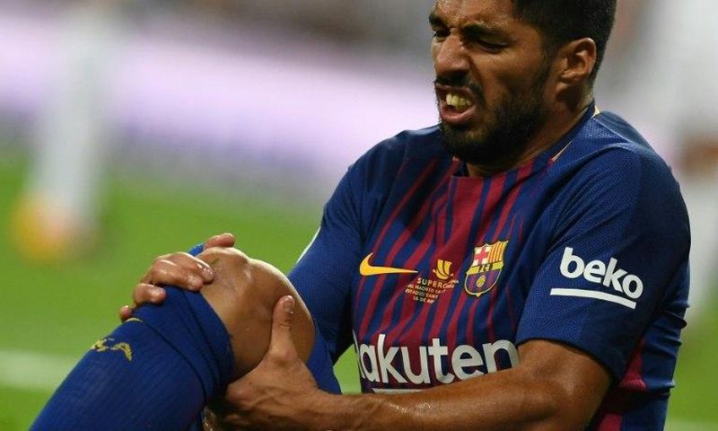 Barcelona's Uruguayan forward Luis Suarez grimaces as he sits on the ground during the Spanish Supercup match against Real Madrid in Madrid, on August 16, 2017