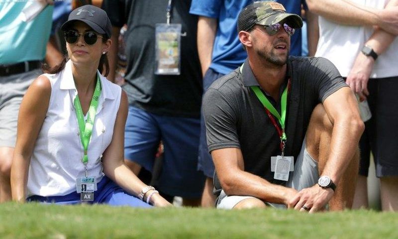 Swimmer Michael Phelps and his wife Nicole Johnson look on during the first round of the 2017 PGA Championship at Quail Hollow Club on August 10, 2017 in Charlotte, North Carolina