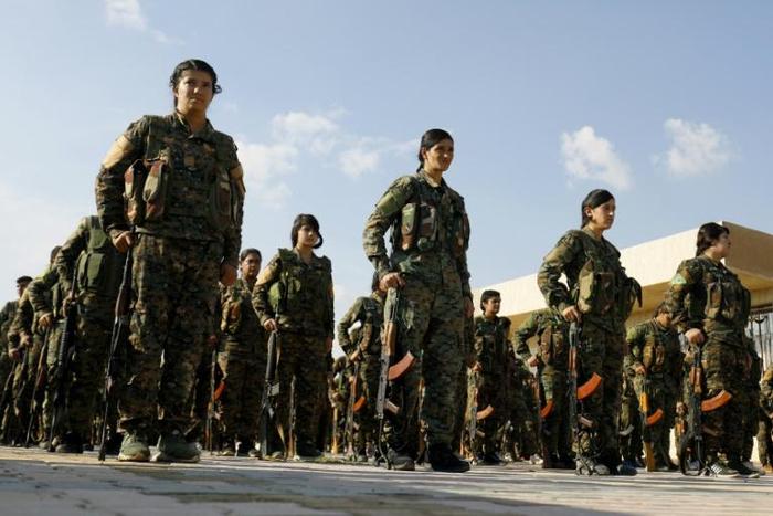 Fighters of the Kurdish-led Syrian Democratic Forces parade at the funeral on November 11, 2018 of a comrade killed in the US-backed campaign against the Islamic State group that President Donald Trump now says is over