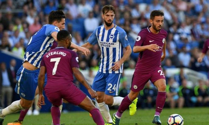 Manchester City's Bernardo Silva (R) runs with the ball during their English Premier League match against Brighton & Hove Albion, at the American Express Community Stadium in Brighton, on August 12, 2017
