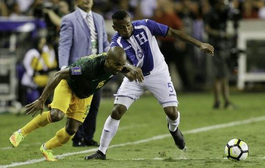 Florent Malouda (L) of French Guiana fights for the ball with Ever Alvarado of Honduras, at BBVA Compass Stadium in Houston, Texas, on July 11, 2017