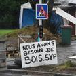 One of the 'yellow vest' protesters helps the construction work at a roundabout in Brest, western France. The sign next to him reads '"We need more wood, please'.