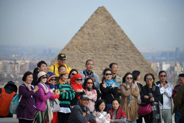 Tourists pose for a group picture at the Giza pyramids on the southwestern outskirts of the Egyptian capital Cairo on December 29, 2018