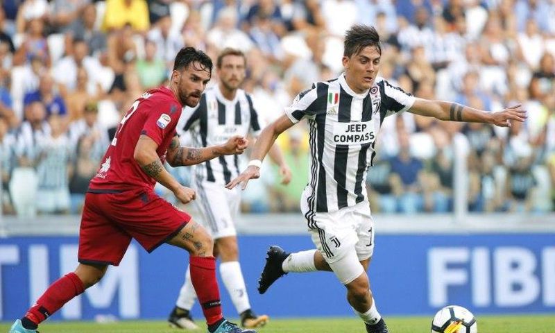 Juventus' forward Paulo Dybala (R) fights for the ball with Cagliari's midfielder Luca Cigarini during the Italian Serie A football match August 19, 2017