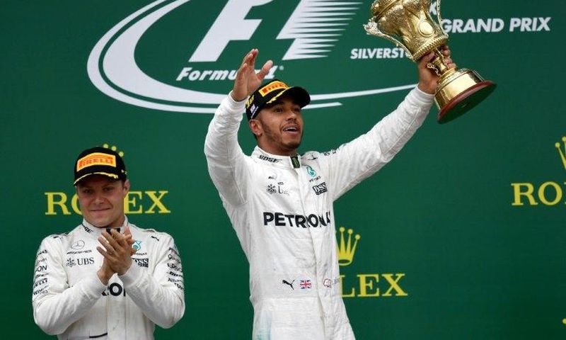 Mercedes' British driver Lewis Hamilton (right) celebrates next to second-placed Mercedes' Finnish driver Valtteri Bottas after winning the British Formula One Grand Prix in Silverstone on July 16, 2017
