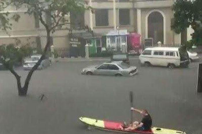 An expat seen paddling a canoe in flooded Victoria Island.