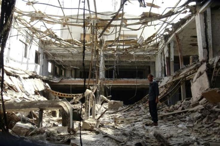 A man inspects the ruins of a factory hit by fierce fighting for the Yemeni port city of Hodeida that a UN-brokered truce which went into effect on Tuesday is intended to halt
