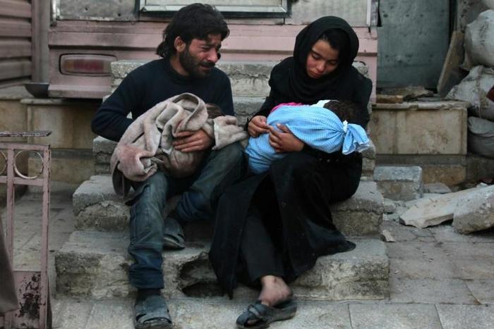 A Syrian couple mourn for one of their children in the rebel-held besieged town of Douma following who died in air strikes on the Eastern Ghouta region on the outskirts of the capital Damascus