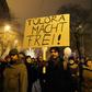 A protester holds a placard, reading 'Overtime sets you free' referring to the German phrase meaning "work sets you free" used at the entrance of the Auschwitz concentration camp, at a protest march against Hungary's new labour reform law