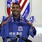 Argentine striker Carlos Tevez posing with a jersey of his new club Shanghai Shenhua during a press conference in Shanghai, on January 21, 2017