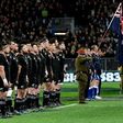 New Zealand (L) and Australia rugby players observe a moment of silence due to the passing of All Blacks legend Colin Meads, in Dunedin, on August 26, 2017