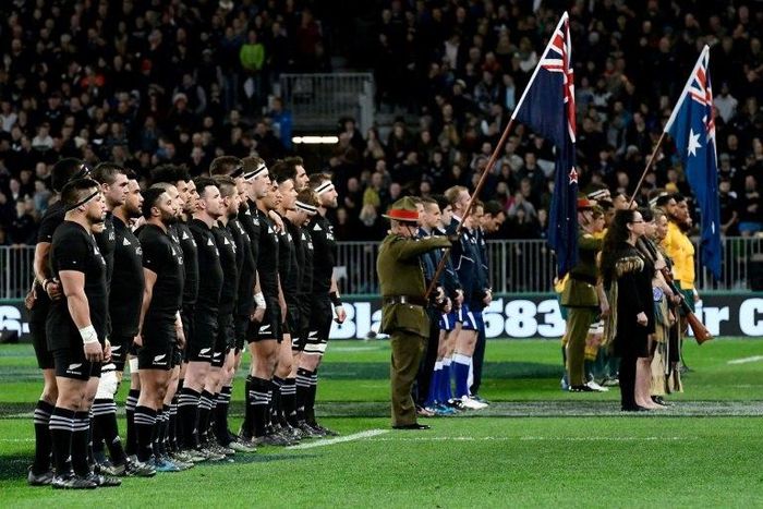 New Zealand (L) and Australia rugby players observe a moment of silence due to the passing of All Blacks legend Colin Meads, in Dunedin, on August 26, 2017